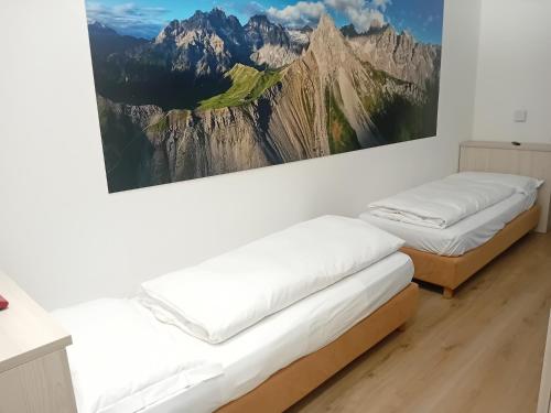 une chambre avec deux lits et un tableau au mur dans l'établissement Hotel Venezia, à Rocca Pietore