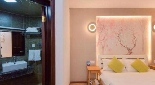 een slaapkamer met een bed en een badkamer met een bad bij Dali Four Seasons Hostel in Dali (oude stad)