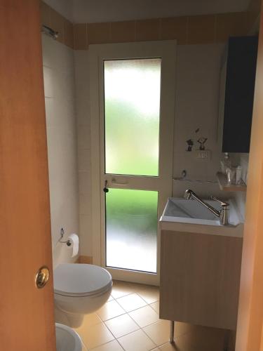 a bathroom with a toilet and a sink and a window at A Casa di Diamante in Bisceglie