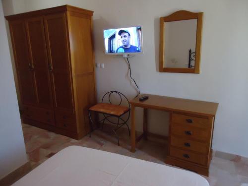 a bedroom with a desk and a tv on the wall at Hotel Antequera Rural Fortes La Nuit in Mollina