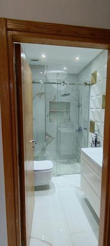 een badkamer met een douche, een toilet en een wastafel bij Temara wifak in Temara