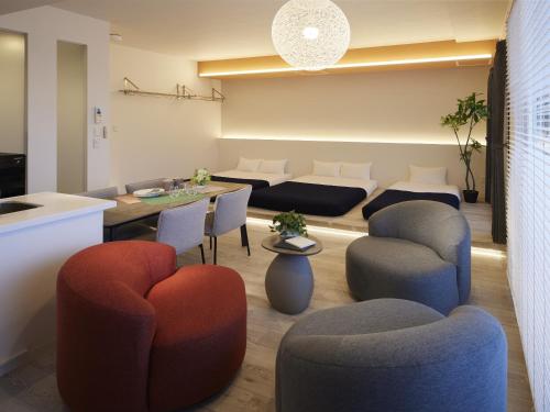 a living room with couches and a table and chairs at Minn Chitose in Chitose