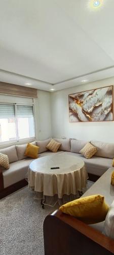 een woonkamer met een bank en een tafel bij Temara wifak in Temara