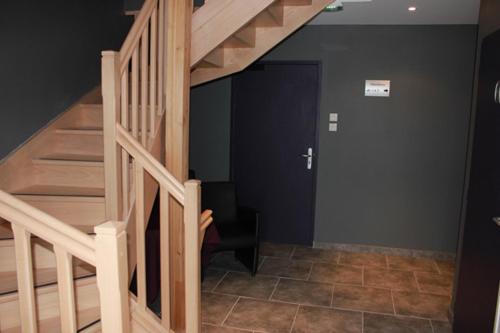 a wooden staircase in a room with a door at La Source in Porcieu-Amblagnieu