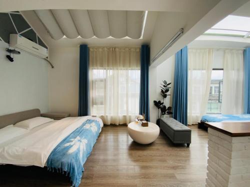 a bedroom with a large bed and a tub in it at 叁三民宿 in Dali