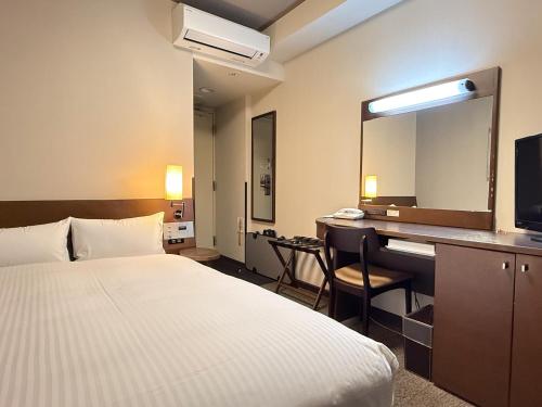 ein Hotelzimmer mit Bett und Schreibtisch in der Unterkunft Hotel Route-Inn Ichinoseki Inter in Ichinoseki
