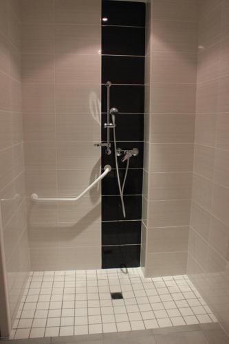 a shower in a bathroom with a tiled floor at La Source in Porcieu-Amblagnieu