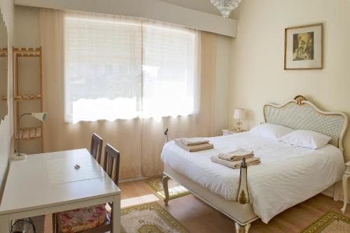 a bedroom with a bed and a table and a window at Burgo's House in Porto