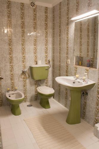 a bathroom with a toilet and a sink and a toilet istg at Burgo's House in Porto