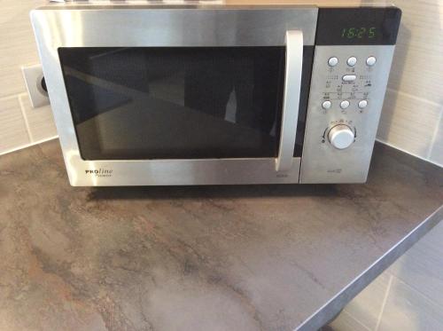 a microwave oven sitting on top of a counter at Appart Hôtel l'Orchidée in Morangis