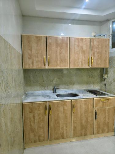 a kitchen with wooden cabinets and a sink at فندق جراند روز in Najran