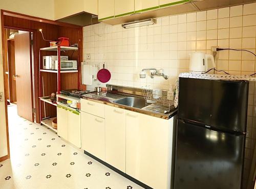 a kitchen with a black refrigerator and a sink at Japanese Cozy House Near Nagoya Station in Nagoya