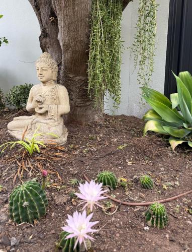 a statue of a buddha sitting under a tree at Avenue rd Clarence Gardens in Clarence Park
