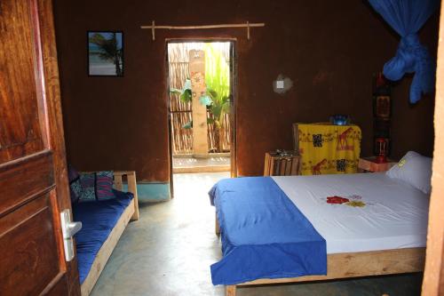 a bedroom with a bed and a door with a window at Bahati Diani House Glamping in Diani Beach