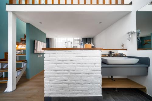 a bathroom with a sink and a white brick wall at 叁三民宿 in Dali