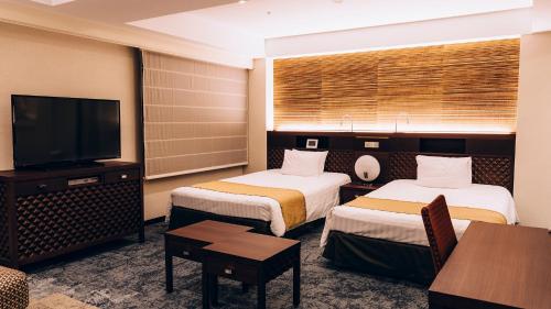 a hotel room with two beds and a flat screen tv at Shinagawa Tobu Hotel in Tokyo