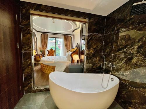 a bathroom with a bath tub in a room at Royal Hotel Hà Nội in Lưu Phái