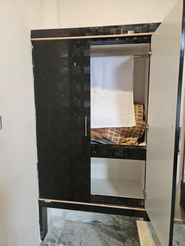 an open microwave oven with a basket inside at Pandit Devki Nandan Dharamsala & Guest House in Deoghar