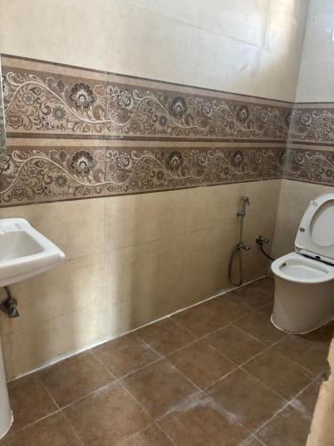 een badkamer met toilet en wastafel bij Hathayogashram Hostel in Rishīkesh