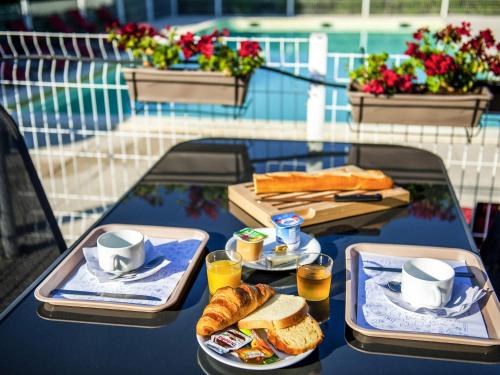 een tafel met twee dienbladen met eten en brood erop bij Ibis Budget Hyères in Hyères