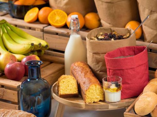 une table garnie de pain, de fruits et d'une bouteille de lait dans l'établissement ibis budget Orly Rungis, à Rungis