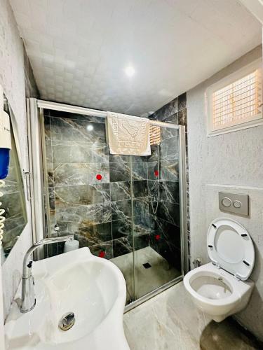 a bathroom with a shower and a toilet and a sink at Fİi SUİTES in Kumluca
