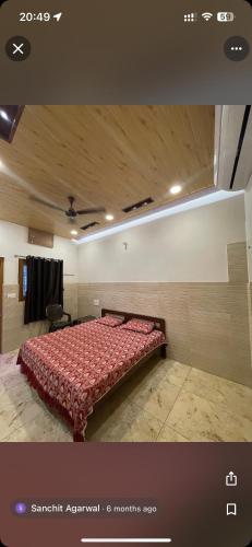 a bedroom with a bed with a red comforter at Hotel Utsav in Khatīma