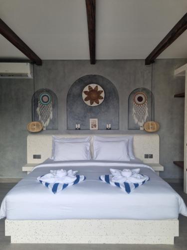 een slaapkamer met een groot wit bed en uilen op de muur bij Agusta Villas in Uluwatu