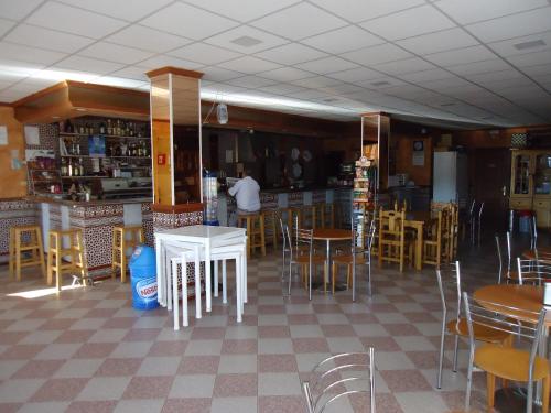 a restaurant with tables and chairs and a man in a kitchen at Hotel Antequera Rural Fortes La Nuit in Mollina
