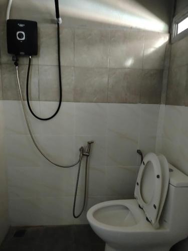 a bathroom with a white toilet and a shower at Tokpa Tokma's Haven in Jertih