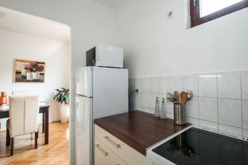 a kitchen with a white refrigerator and a table at Sensitive Apartment in Belgrade