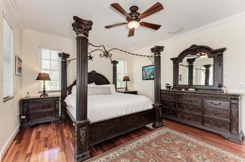 een slaapkamer met een groot bed en een plafondventilator bij Villa Di Palma 5BD 4BR in Anna Maria