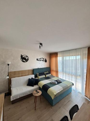 een slaapkamer met een groot bed en een groot raam bij Apartman Dan i Noć in Divčibare