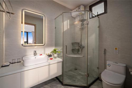 een badkamer met een wastafel en een glazen douche bij KLY Hotel in Hue