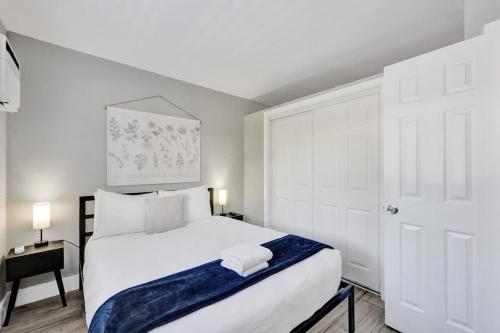 a bedroom with a white bed with a blue blanket on it at Rustic Retreats Cozy 1BR For 4 Guests Minutes From Las Olas in Fort Lauderdale
