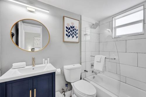 a bathroom with a sink and a toilet and a mirror at Rustic Retreats Cozy 1BR For 4 Guests Minutes From Las Olas in Fort Lauderdale