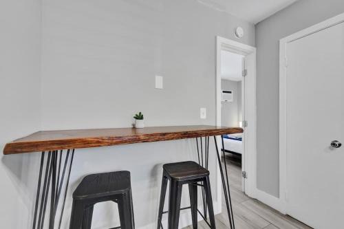 a bar with two stools in a room at Rustic Retreats Cozy 1BR For 4 Guests Minutes From Las Olas in Fort Lauderdale