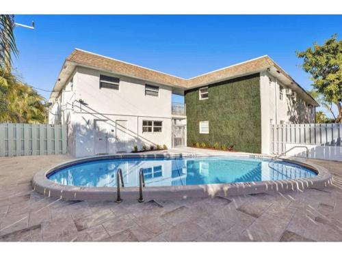 a swimming pool in front of a house at Rustic Retreats Cozy 1BR For 4 Guests Minutes From Las Olas in Fort Lauderdale