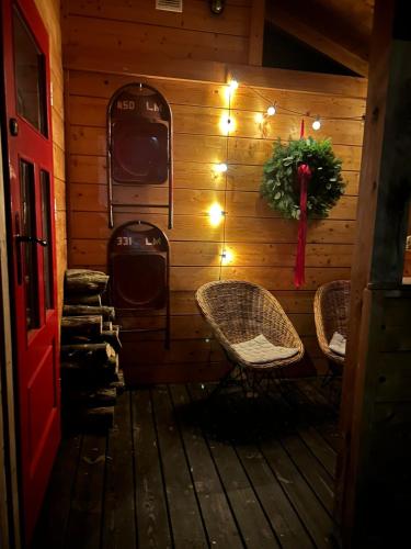 a porch with two chairs and a wreath and lights at Domek w Janowcu in Janowiec