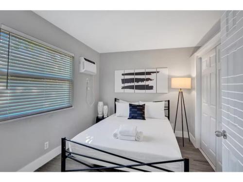 a bedroom with a large white bed with a window at Rustic Retreats Beachy 1BR for 4 guests in the heart of Fort Lauderdale in Fort Lauderdale