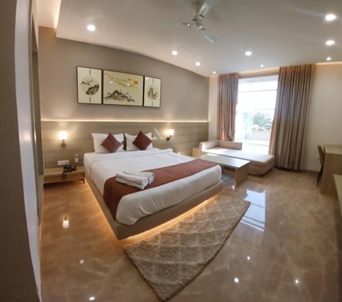 a bedroom with a large bed and a large window at The Riverside Inn in Vidisha
