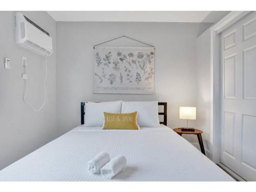 a bedroom with a white bed with two towels on it at Rustic Retreats Cozy 1BR For 4 Guests In The Heart Of Fort Lauderdale in Fort Lauderdale