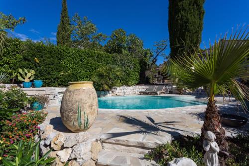 a large stone vase sitting next to a swimming pool at La Bergerie in Saint-Jeannet