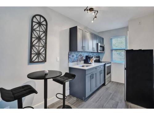a kitchen with a sink and a table and a counter at Rustic Retreats Cozy 1BR For 4 Guests Minutes From Las Olas in Fort Lauderdale