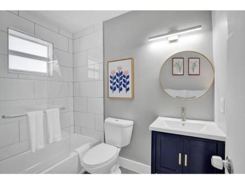 a white bathroom with a toilet and a sink at Rustic Retreats Cozy 1BR For 4 Guests Minutes From Las Olas in Fort Lauderdale