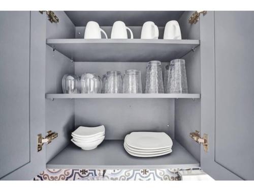 a pantry with plates and bowls on shelves at Rustic Retreats Cozy 1BR For 4 Guests Minutes From Las Olas in Fort Lauderdale