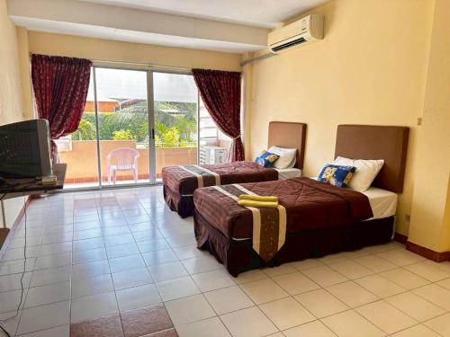 una camera d'albergo con due letti e un balcone di ระยองบีช Rayong Beach Hotel a Ban Chak Phai