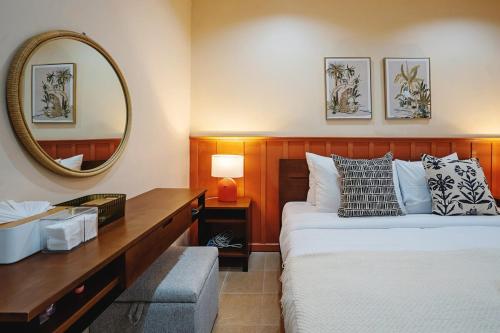 a bedroom with a bed with a desk and a mirror at Peridot Pool Beach in Chaweng Noi Beach