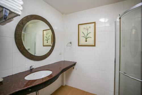 een badkamer met een wastafel en een spiegel bij Mae Pim Resort Hotel in Mae Pim