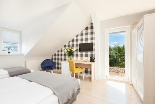 a bedroom with a bed and a desk and a window at Villa Milla in Łeba